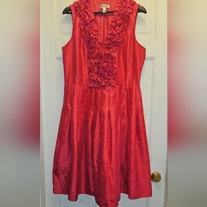 Chic sleeveless dress with ruffled front and neckline, in a vibrant orange red